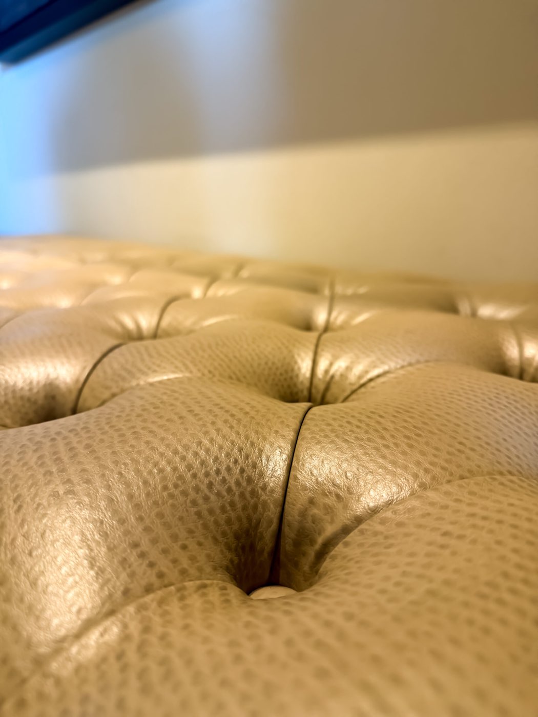Macro detail of hand-tufted upholstery, showing the button and stitch work