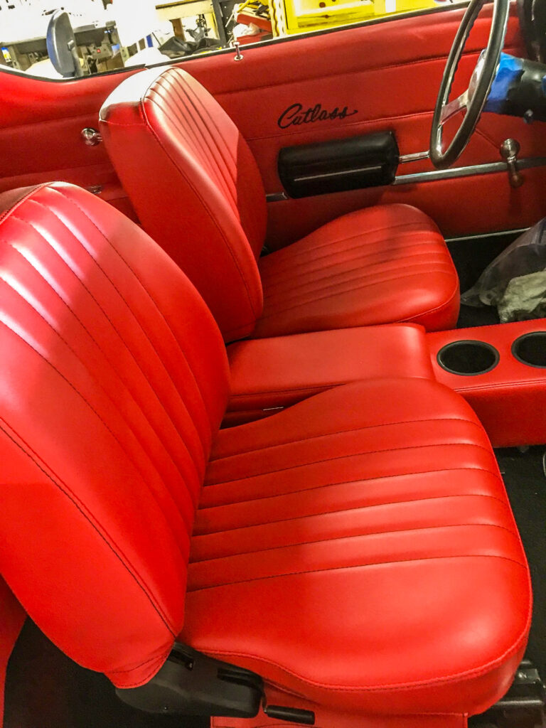 Red leather bucket seats reupholstered in a classic Oldsmobile Cutlass by American Upholstery