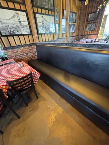 After: black vinyl wall banquette along brick wall