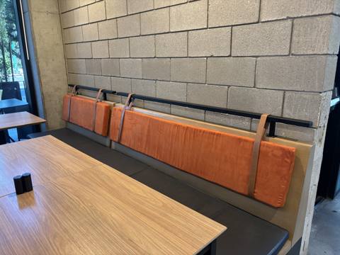 After: orange suede bench backs on rail, dining area