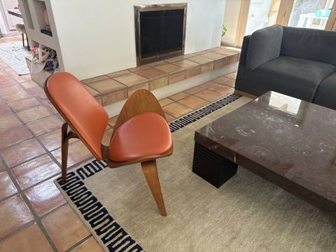 After: orange leather three-leg shell chair in living room